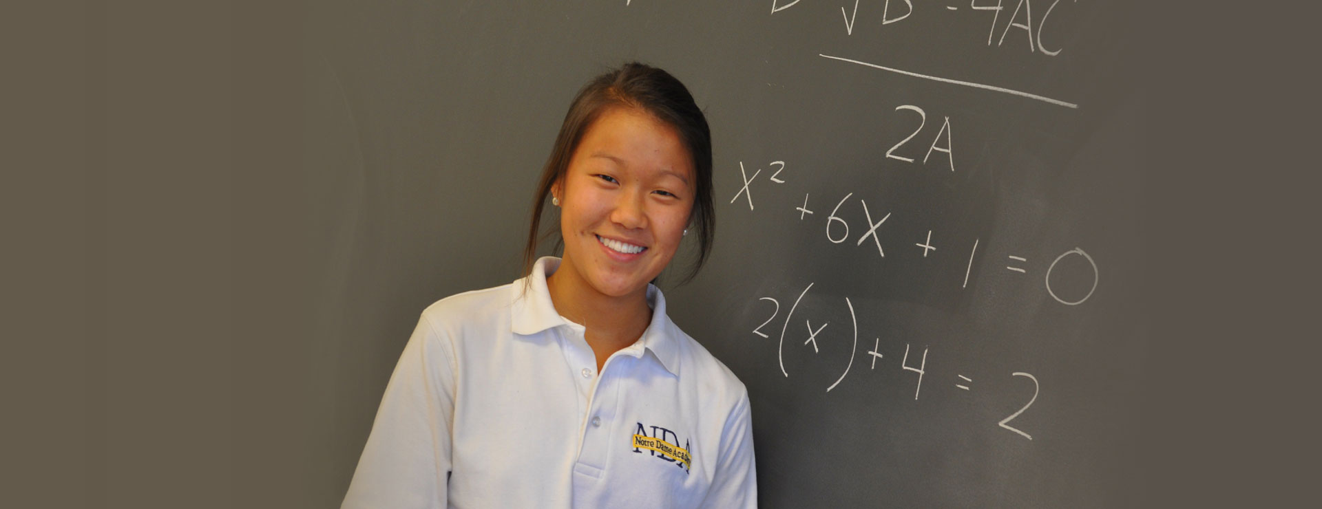 A student standing in front of a chalkboard containing a math equation Notre Dame Academy catholic all girls school students praying in the campus chapel in Northern Kentucky.