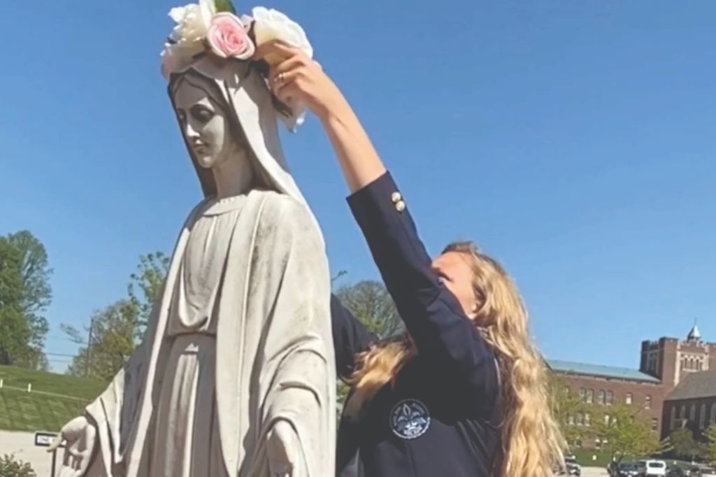 A student 'crowning' the statue of Mary with roses at the Notre Dame Academy catholic all-girls school in Covington, Northern Kentucky.