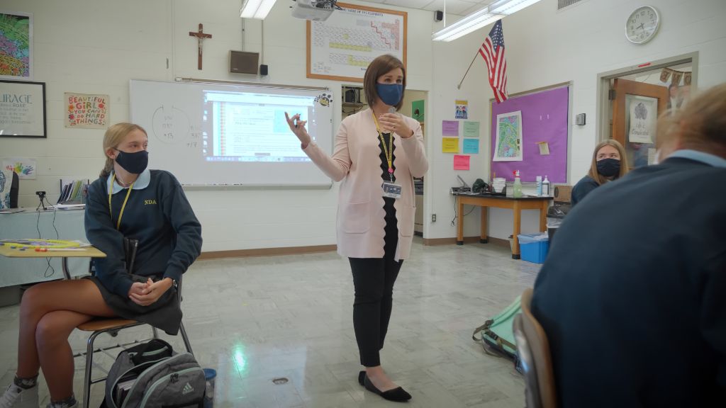 A teacher wearing a protective face mask lecturing students who are also wearing protective face-masks at the Notre Dame Academy catholic all-girls school in Covington, Northern Kentucky.