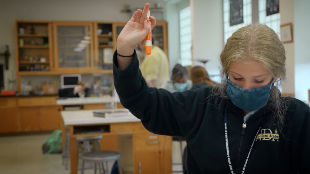 A student raising their hand to ask a question in class at the Notre Dame Academy catholic all-girls school in Covington, Northern Kentucky.