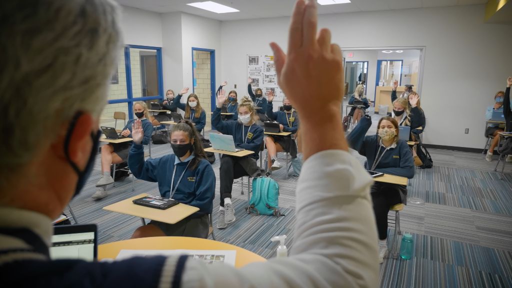 A view over a teacher's shoulder of the students in the classroom seated socially distant wearing protective face masks at the Notre Dame Academy catholic all-girls school in Covington, Northern Kentucky.