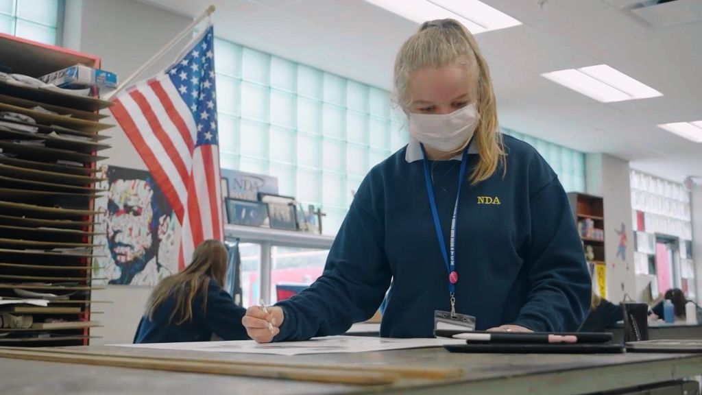A student standing at a table in the art room drawing at the Notre Dame Academy catholic all-girls school in Covington, Northern Kentucky.
