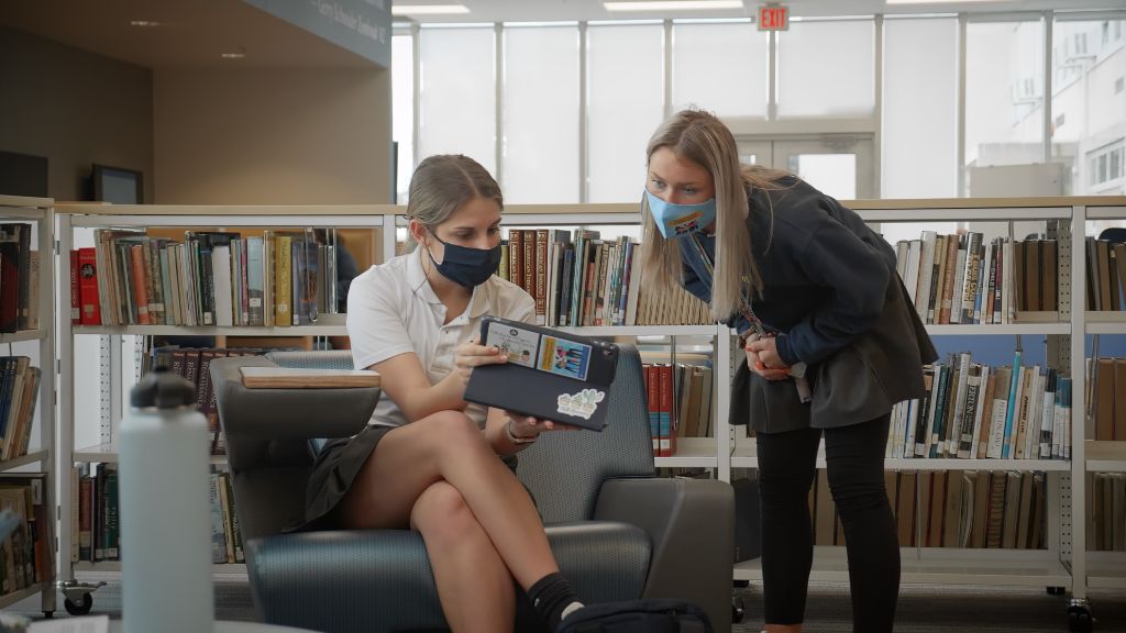 Two students reviewing something on an iPad together in the Library at the Notre Dame Academy catholic all-girls school in Covington, Northern Kentucky.