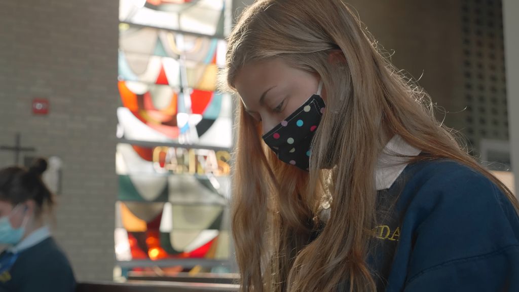 A closeup of a student with their eyes closed praying in the chapel at the Notre Dame Academy catholic all-girls school in Covington, Northern Kentucky.