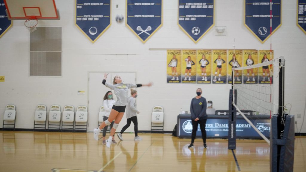 A student athlete jumping to spike a volleyball at the Notre Dame Academy catholic all-girls school in Covington, Northern Kentucky.